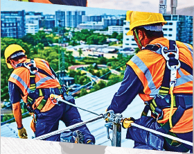 Trabalhador em altura utilizando equipamento de linha de vida em fachada de edifício